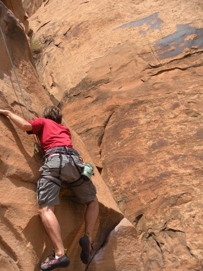 A trip participant struggles to find a hold