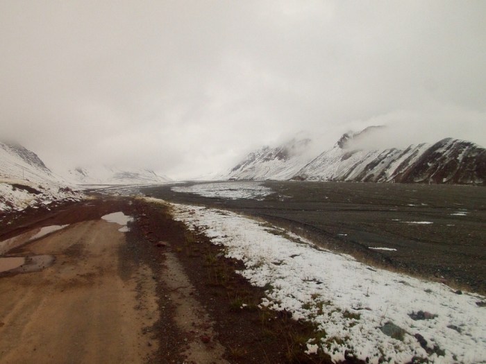 The road and moraine in the uncontrolled border zone between Kyrgyzstan and Tajikistan. It is apparent neither side takes responsibility for maintaining the road.